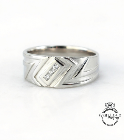 A silver ring with a geometric design and three small diamonds set in the center.
