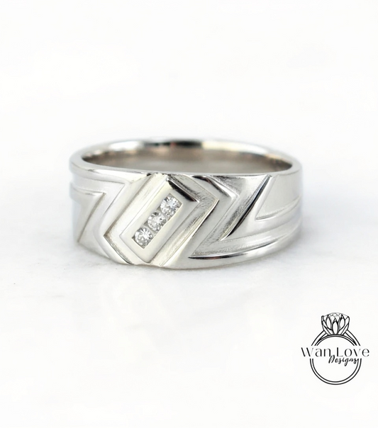 A silver ring with a geometric design and three small diamonds set in the center.