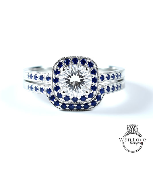 A close-up of a diamond engagement ring with a large central diamond surrounded by smaller diamonds and set in a silver band with blue accents.