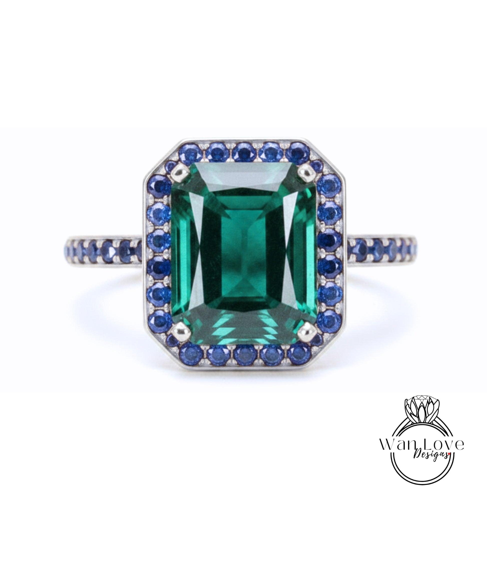 A large, rectangular green gemstone ring with a halo of smaller blue gemstones around the edges.