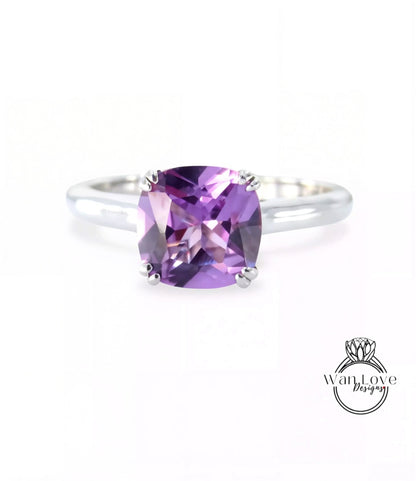 A silver ring with a large, square-cut amethyst gemstone set in the center.