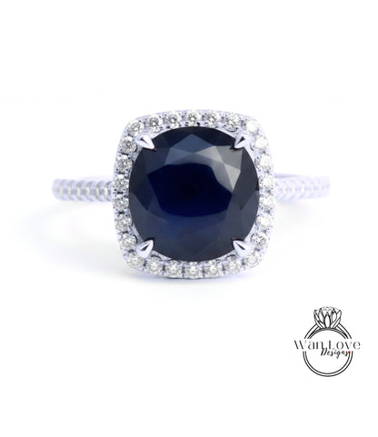 A stunning diamond engagement ring with a large, deep blue gemstone set in a halo of smaller diamonds.