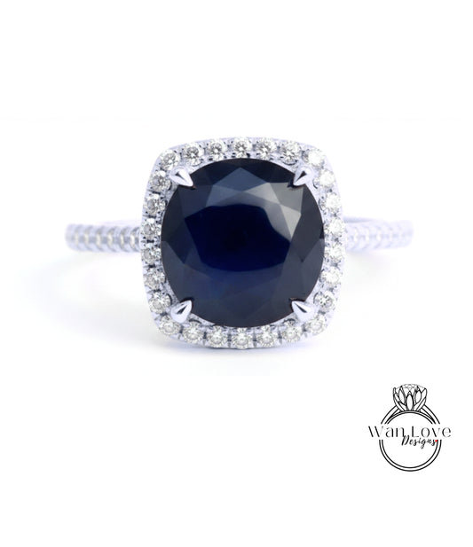 A stunning diamond engagement ring with a large, deep blue gemstone set in a halo of smaller diamonds.