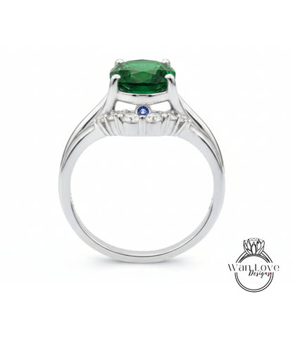 A silver ring with a large green gemstone, possibly a diamond, set in the center.