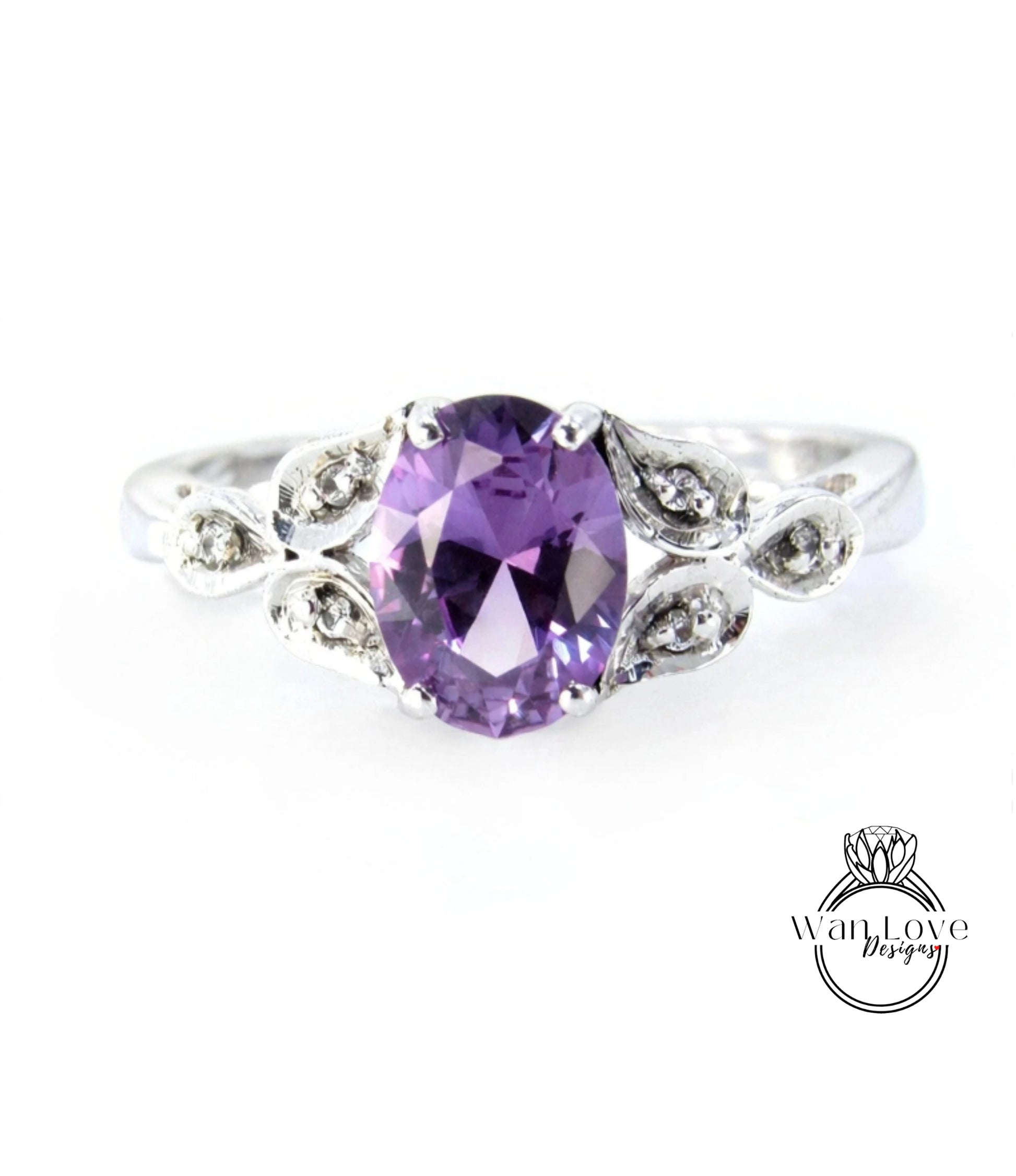 A silver ring with a large oval-shaped purple gemstone, surrounded by small diamonds or crystals.