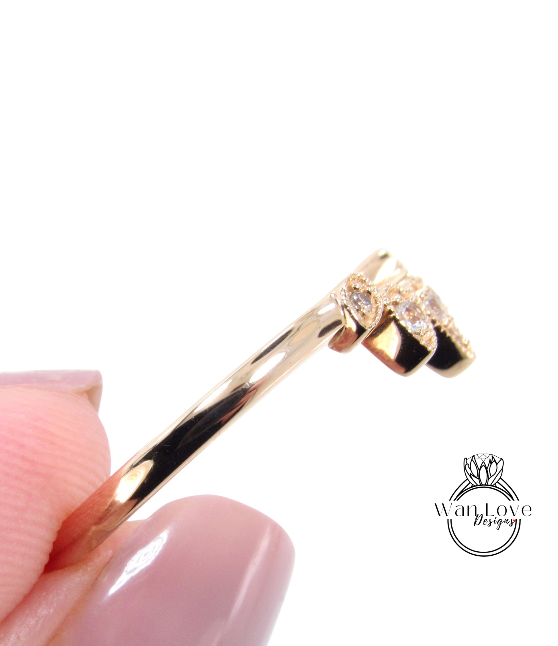 A close-up view of a gold ring being held in a person's hand, with a focus on the ring's design and details.