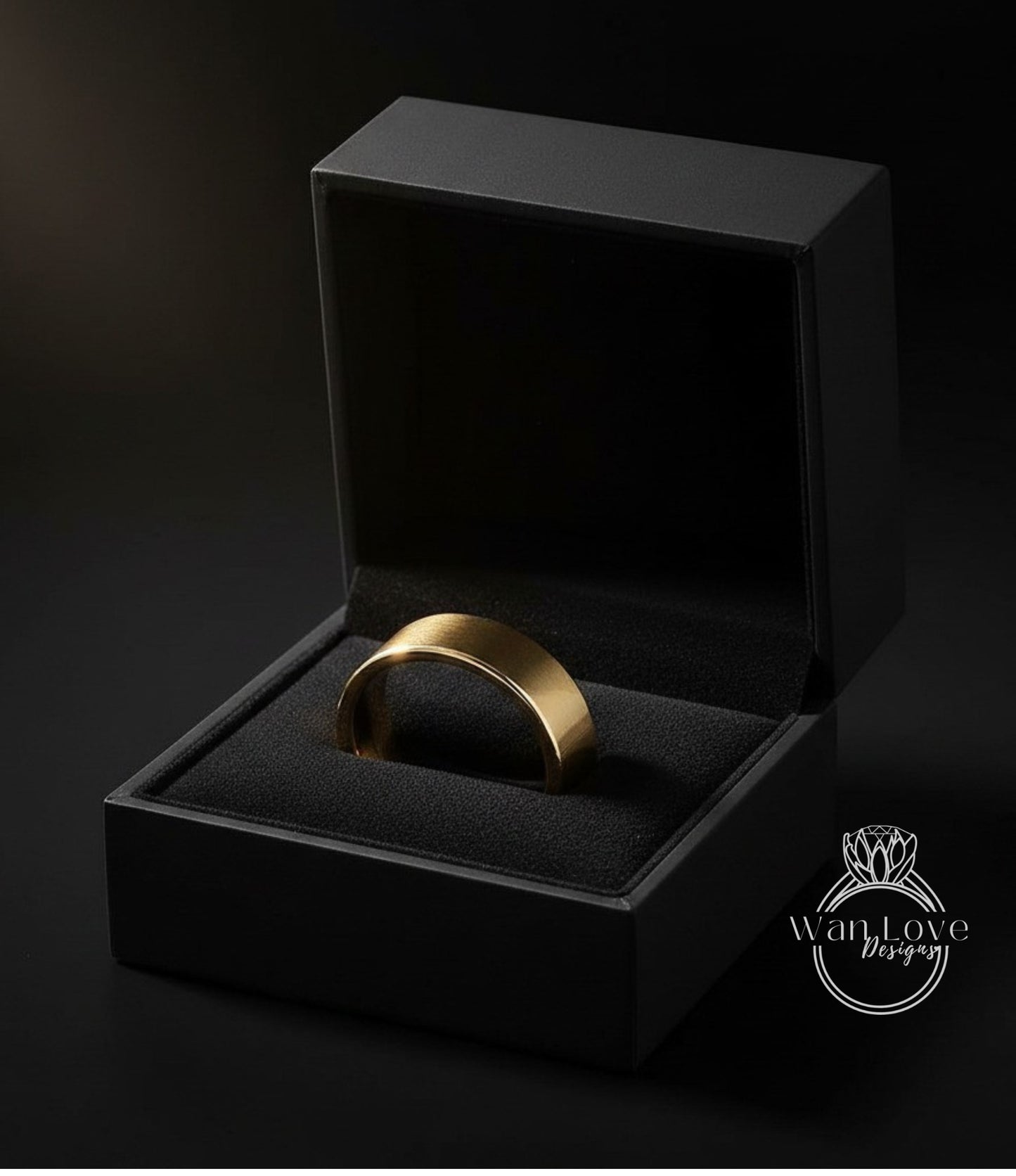 A gold ring is displayed in a black jewelry box against a dark background.