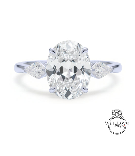 A close-up of a diamond engagement ring with a large oval-shaped diamond set in the center, surrounded by smaller diamonds on either side.