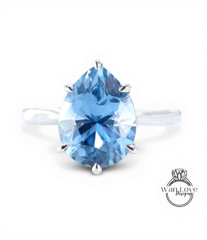 A close-up image of a blue diamond ring with a large, clear gemstone set in a silver band.