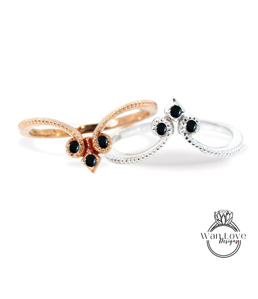 two rings with black gemstones, one silver and one gold, set against a white background.