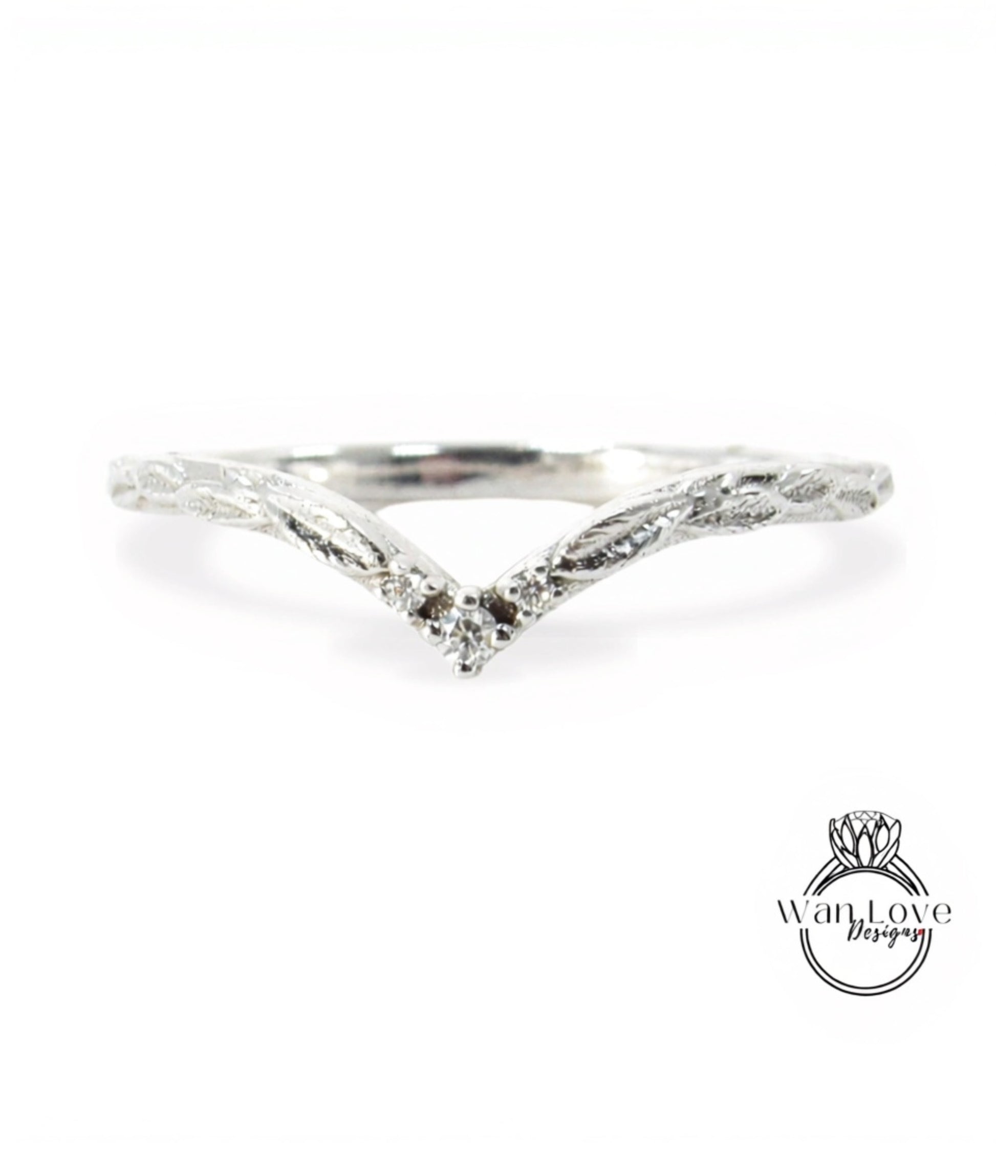 A silver ring with a leaf-like design and a small diamond in the center.