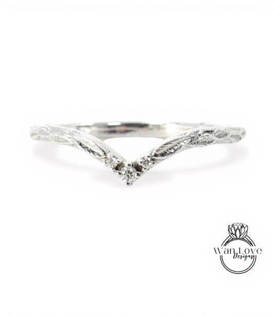 A silver ring with a leaf-like design and a small diamond in the center.