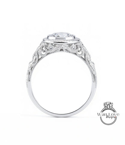 A close-up view of a silver ring with an intricate, decorative design around the band and a large central stone.