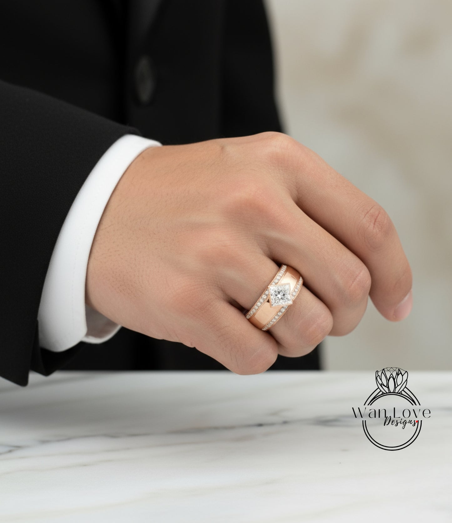 A close-up of a person's hand wearing a gold ring with a diamond, resting on a marble surface.