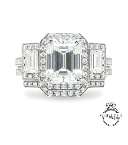 A stunning diamond engagement ring with a large central diamond surrounded by smaller diamonds on either side, set in a silver band.