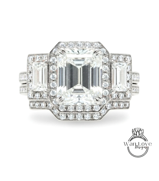 A stunning diamond engagement ring with a large central diamond surrounded by smaller diamonds on either side, set in a silver band.