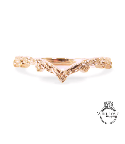 A gold ring with a leaf-like design on the band.