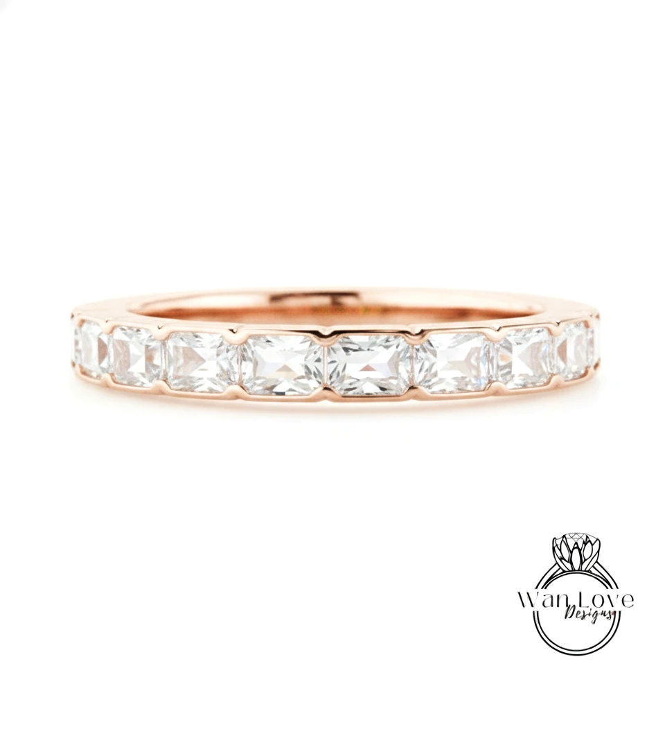 A rose gold band with a row of clear gemstones, likely diamonds, set in the center.