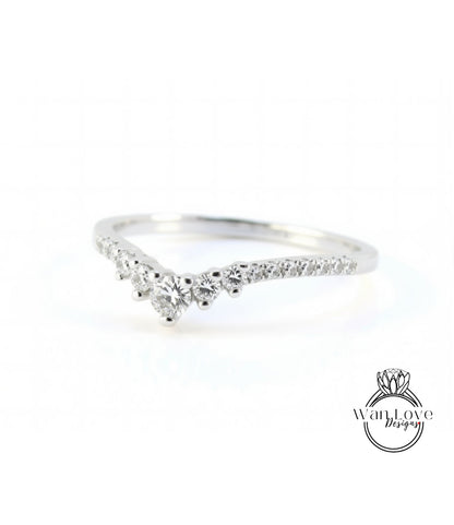 A silver ring with a diamond-encrusted band, featuring a v-shaped design with multiple small diamonds set in the center.