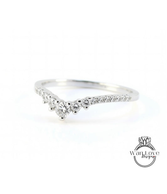 A silver ring with a diamond-encrusted band, featuring a v-shaped design with multiple small diamonds set in the center.