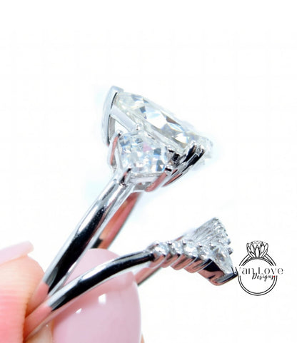 A close-up view of a diamond engagement ring with a large central diamond surrounded by smaller diamonds, held in a hand against a white background.