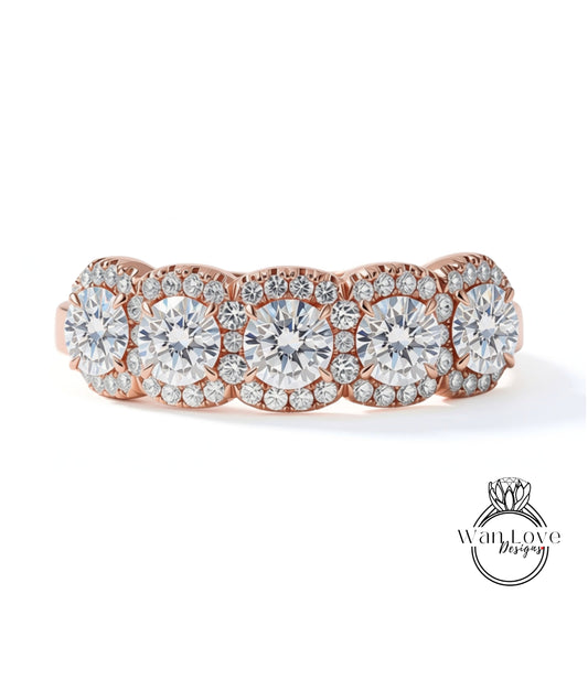 A beautiful rose gold ring with a row of large, sparkling diamonds set in the center.