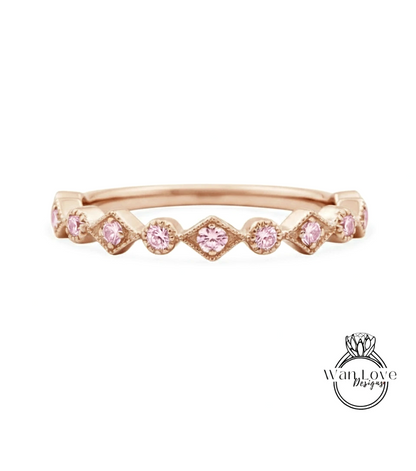 A rose gold ring with a row of pink diamonds set in a diamond pattern.