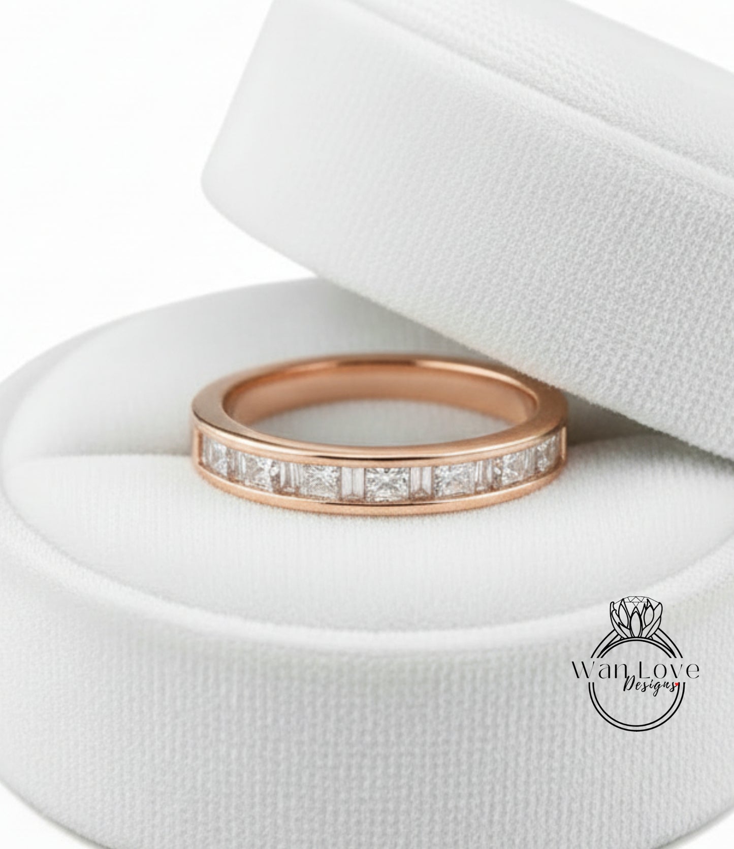 A gold-colored ring with a row of small diamonds set in the band, displayed in a white jewelry box.