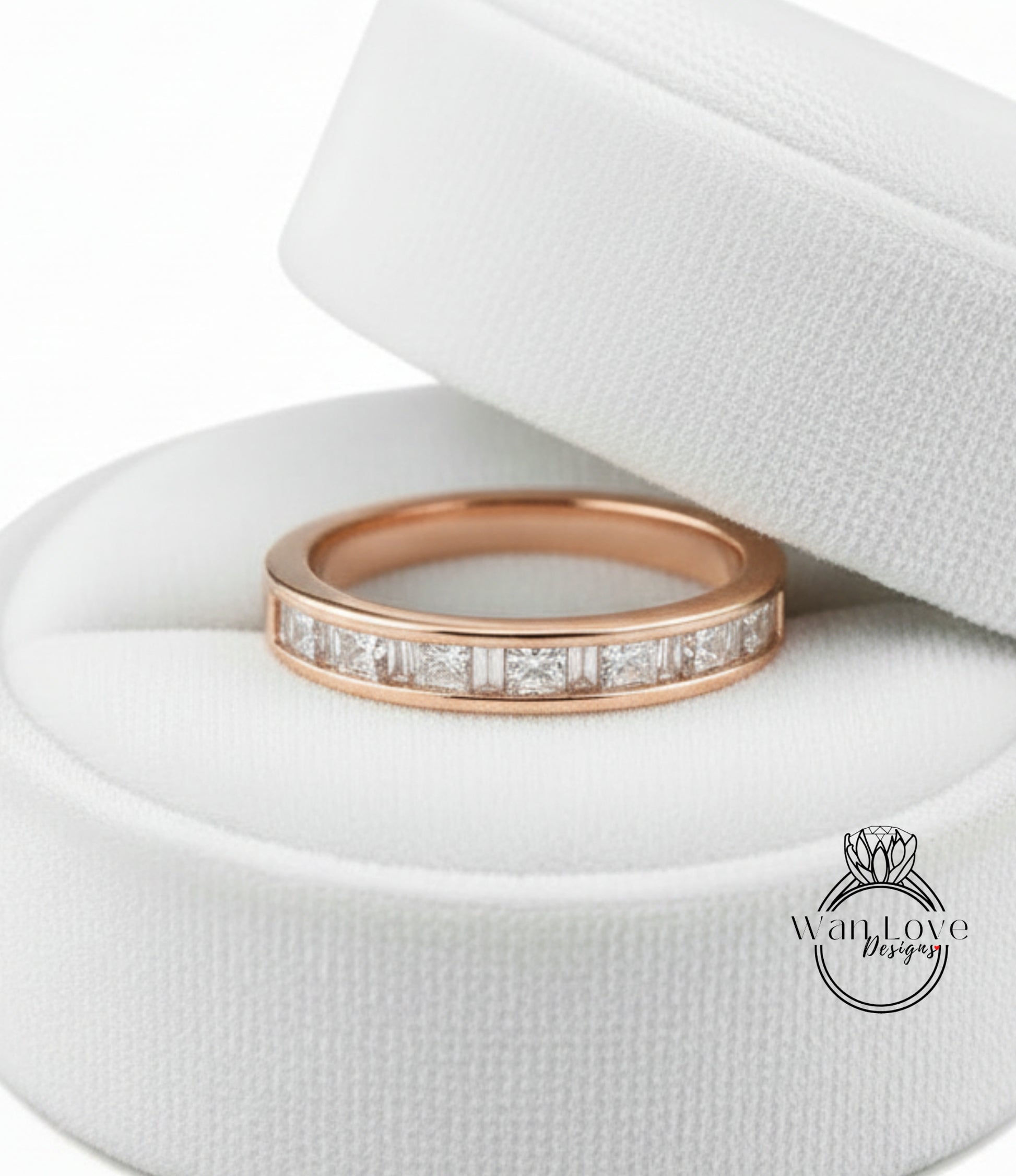 A gold-colored ring with a row of small diamonds set in the band, displayed in a white jewelry box.