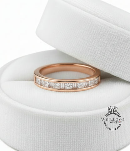 A gold-colored ring with a row of small diamonds set in the band, displayed in a white jewelry box.