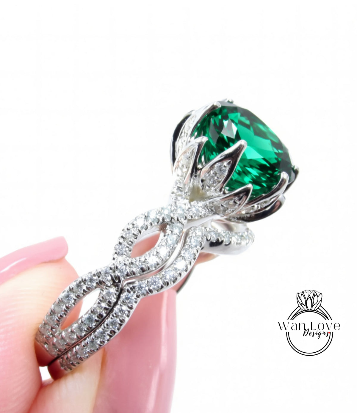 A close-up of a person's hand holding a diamond ring with a large, green gemstone.