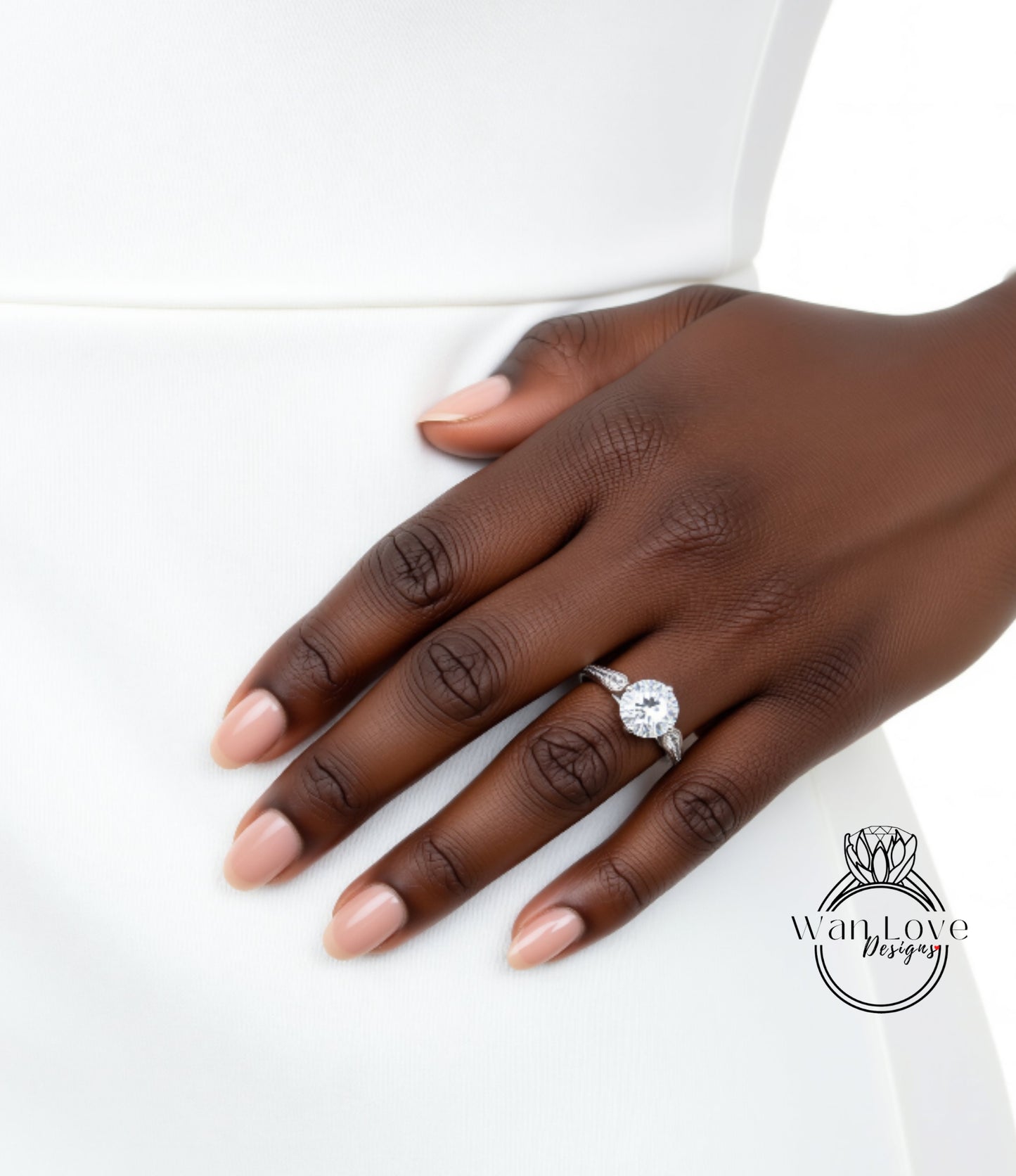 A close-up of a hand wearing a diamond engagement ring.