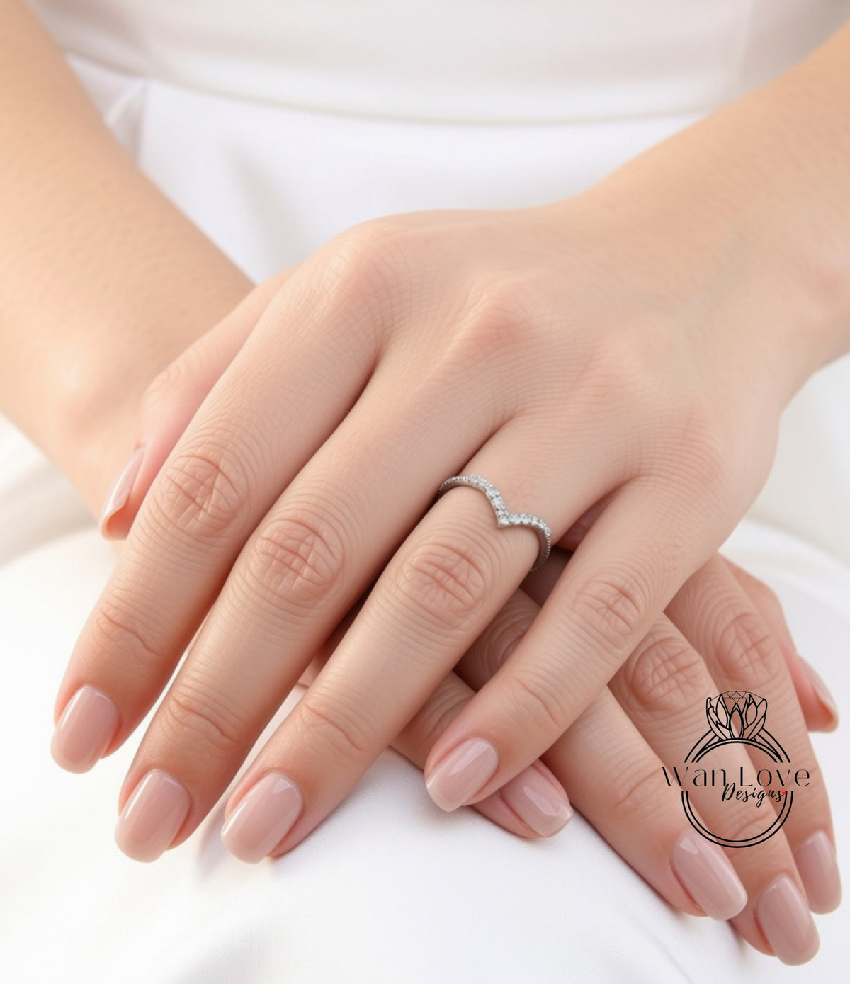 A close-up image of a person's hands wearing a diamond ring.