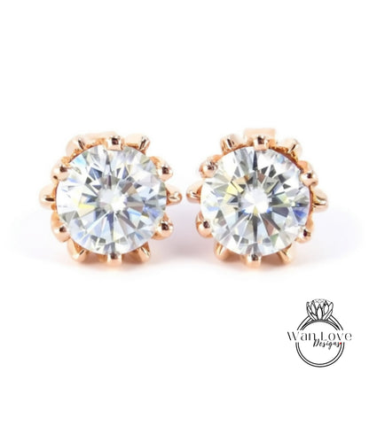 A pair of elegant gold earrings with large, clear diamonds set in a delicate, scalloped design.