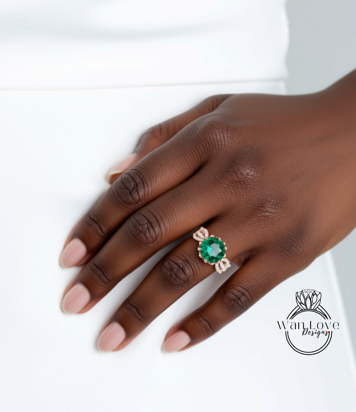 A close-up of a hand wearing a ring with a large green gemstone.