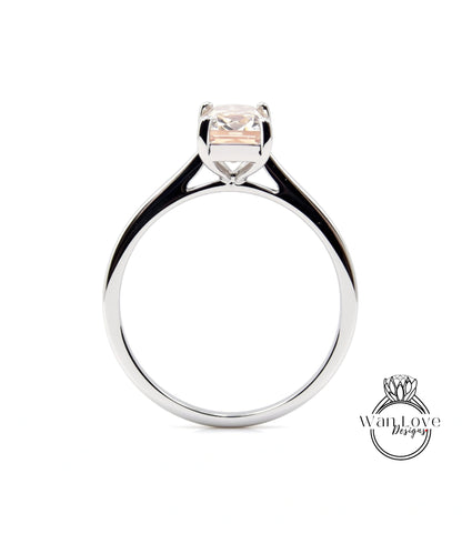 A silver engagement ring with a large, clear gemstone set in the center.