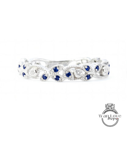 A silver ring with blue gemstones, including blue sapphires, set in a decorative pattern.