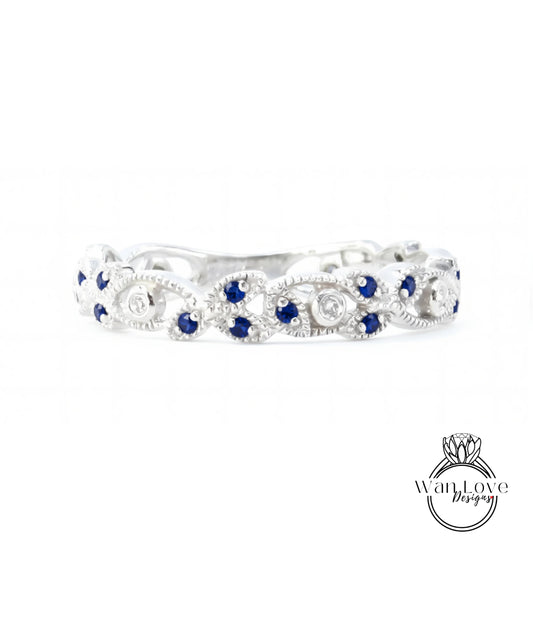 A silver ring with blue gemstones, including blue sapphires, set in a decorative pattern.