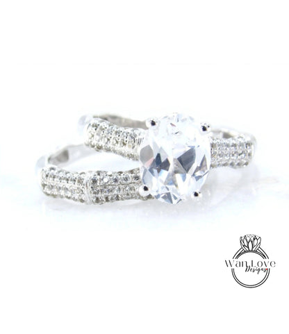 A close-up view of a diamond engagement ring with a large central diamond surrounded by smaller diamonds on either side.