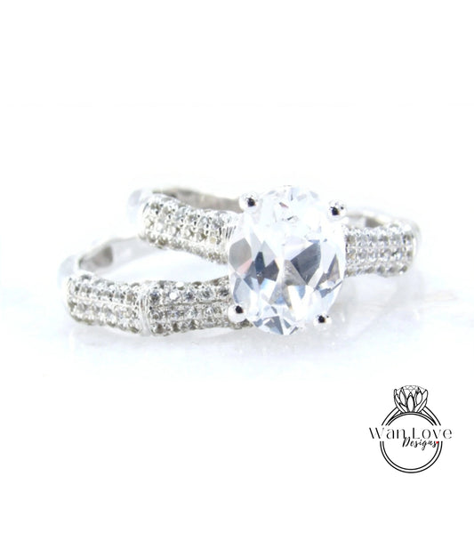 A close-up view of a diamond engagement ring with a large central diamond surrounded by smaller diamonds on either side.
