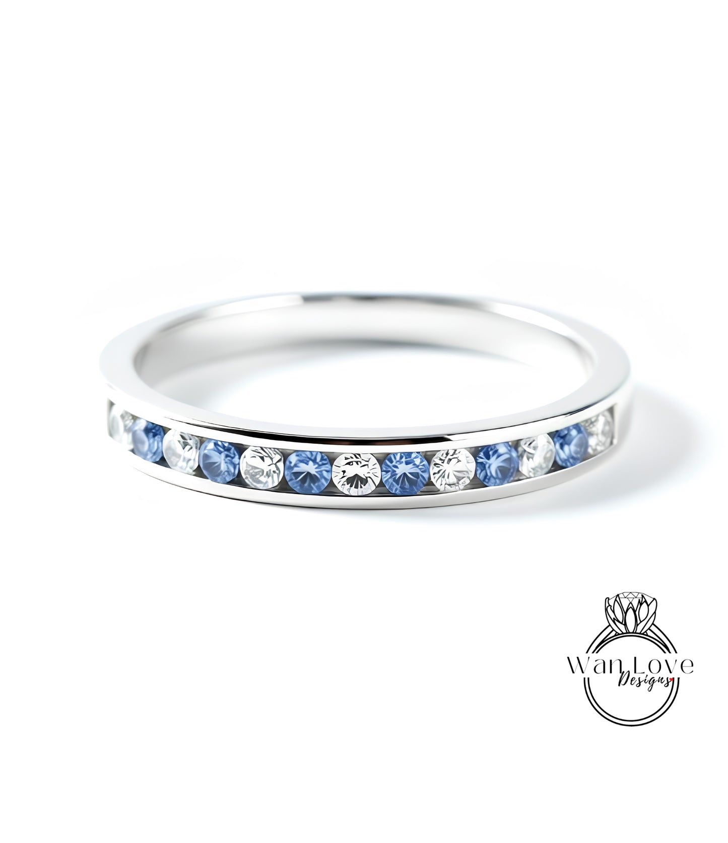 A silver ring with a row of blue and white diamonds set in it.