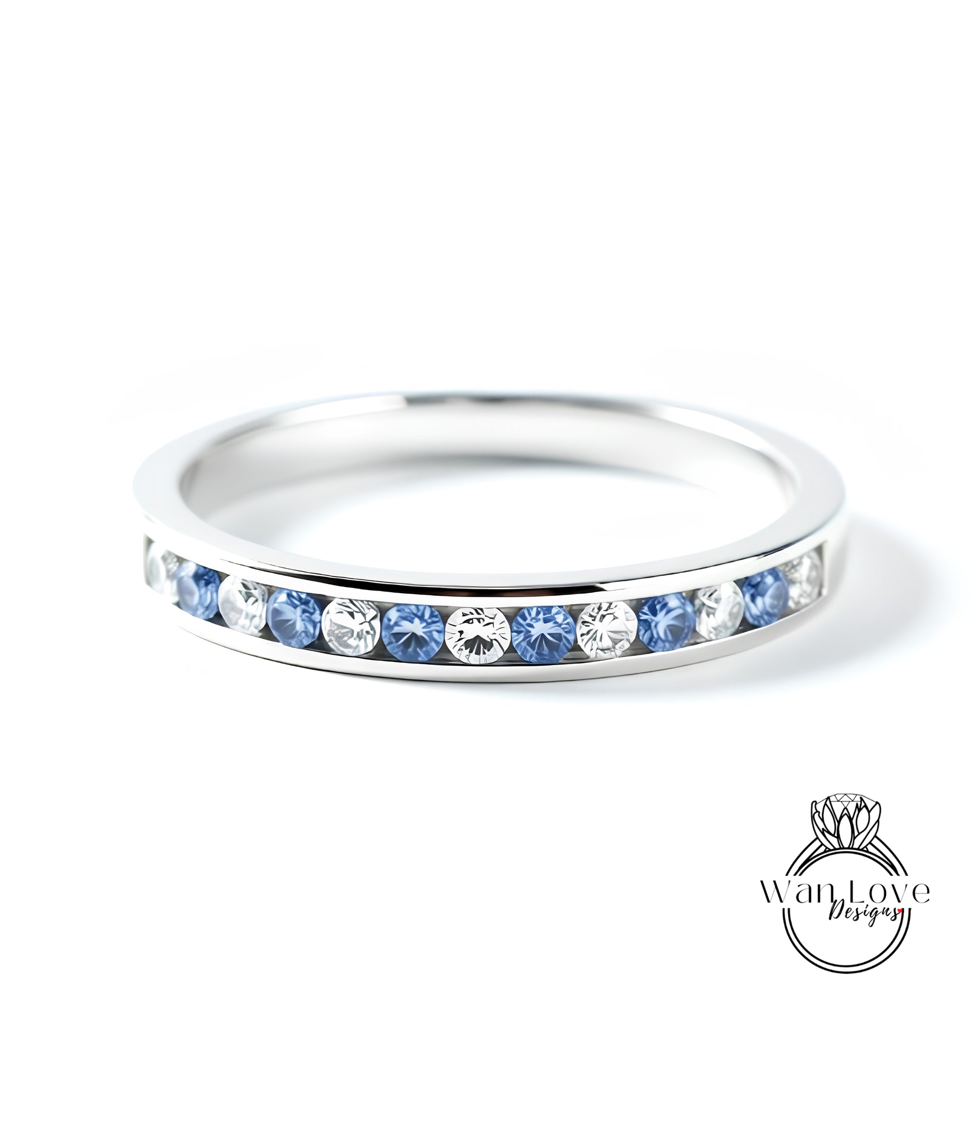 A silver ring with a row of blue and white diamonds set in it.