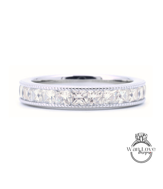 A silver band ring with a row of clear gemstones, likely diamonds, set in a decorative pattern.