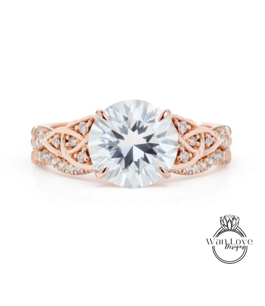 a beautiful engagement ring with a large, clear gemstone set in a rose gold band adorned with intricate designs.