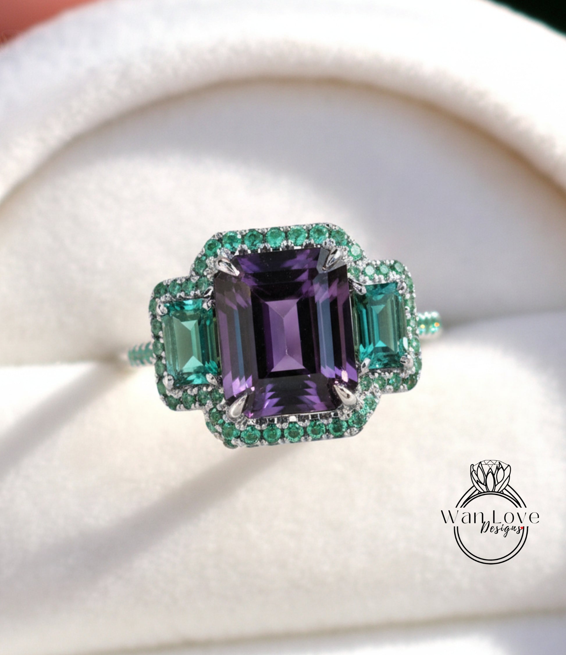 A close-up image of a ring with a large purple gemstone surrounded by smaller green gemstones, set in a silver band.