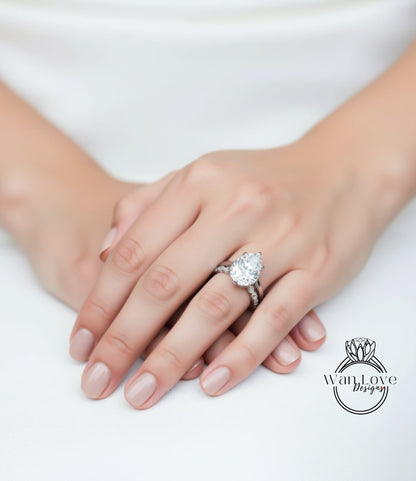 A close-up of a person's hands wearing a large diamond engagement ring.