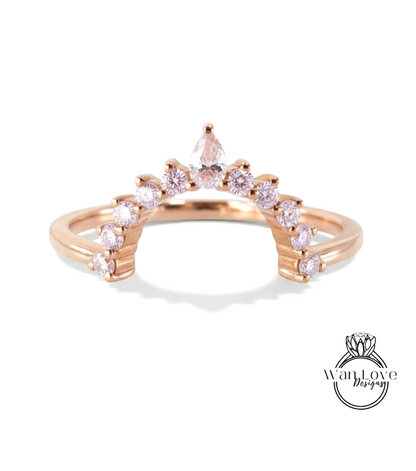 A rose gold ring with a unique design featuring a central diamond surrounded by smaller diamonds arranged in a fan-like pattern.