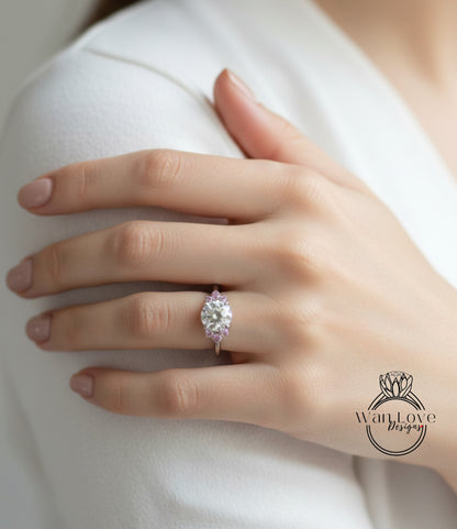 A close-up of a person's hand wearing a diamond engagement ring on the ring finger.