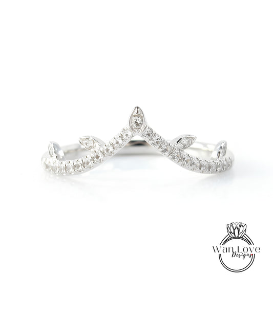 A silver ring with a diamond-encrusted crown-like design.