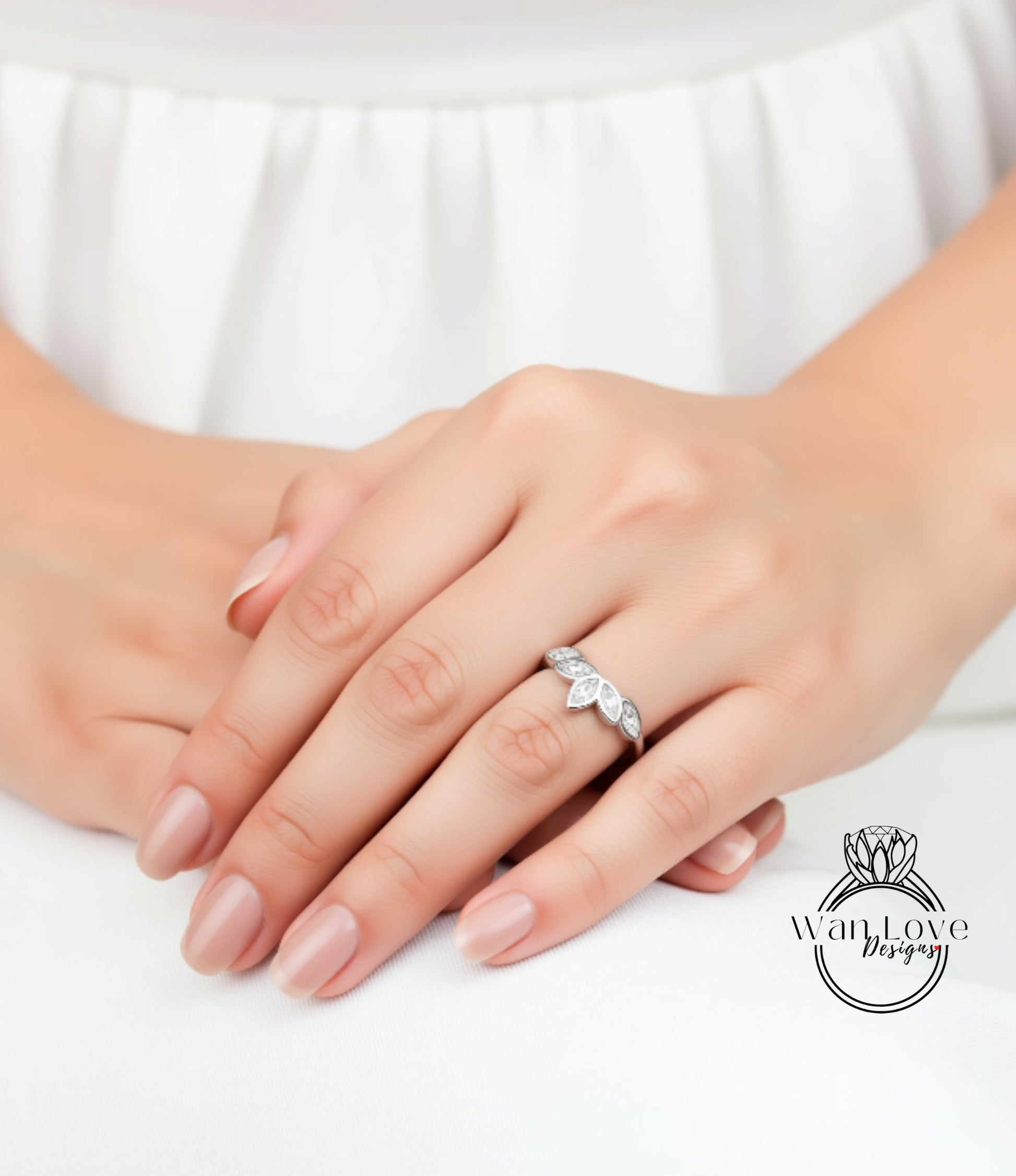A close-up of a person's hand wearing a diamond ring, with the ring's band and stones visible.